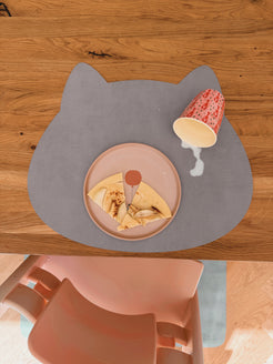 Abwaschbares Kinder-Tischset Katze in Cloudy Gray im Soft LederLook mit verschütteter Milch auf dem Holztisch