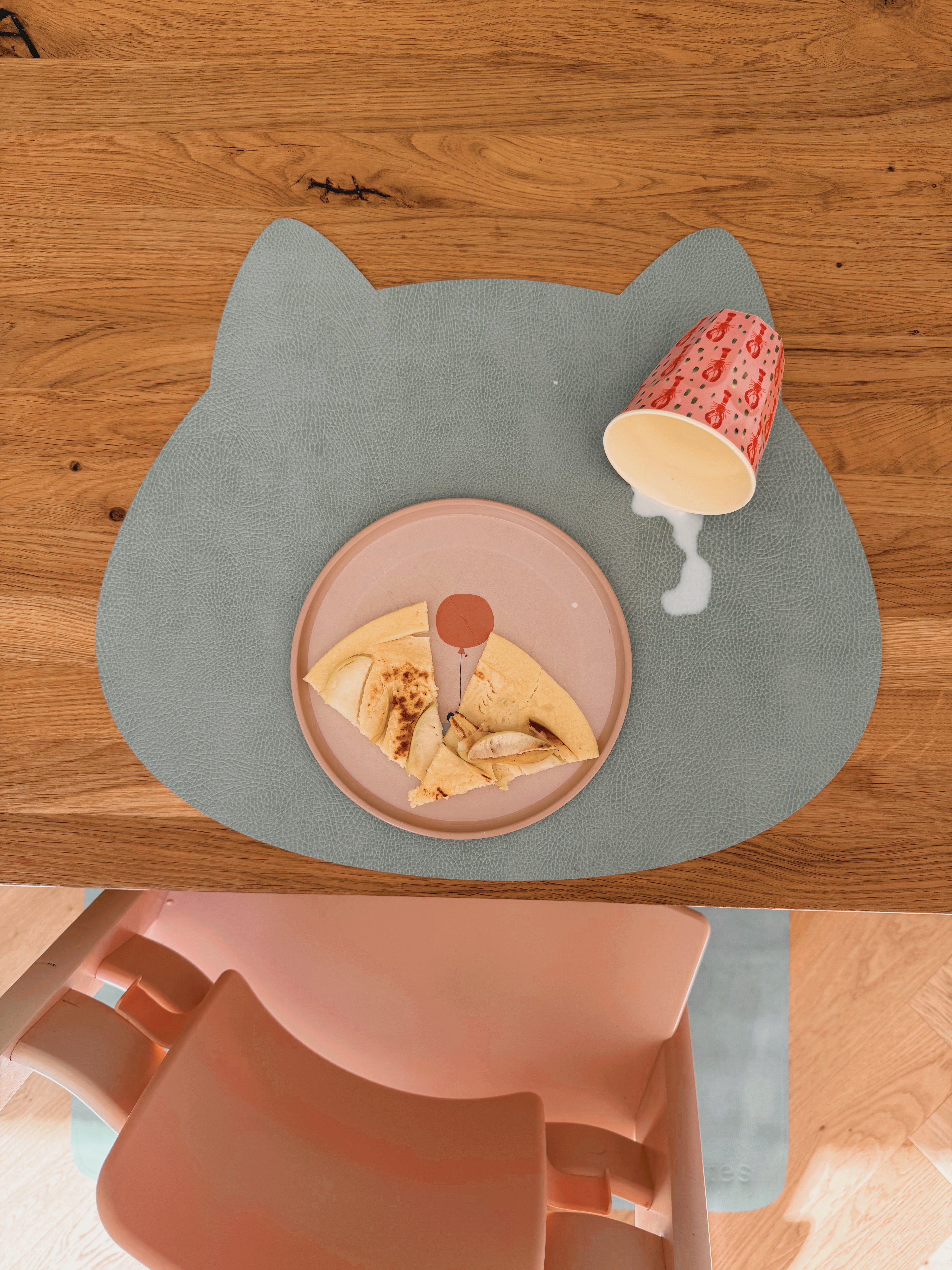 Abwaschbares Kinder-Tischset Katze in Mint Leaf im Soft LederLook mit verschütteter Milch auf dem Holztisch
